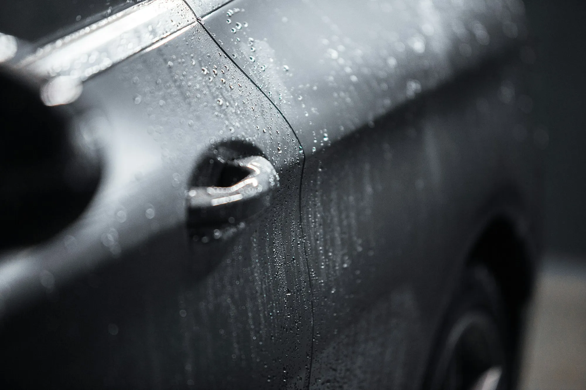 Tight water beads on a coated black car door